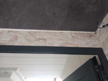 Detalle de tira led en entrada con diseño de piedra